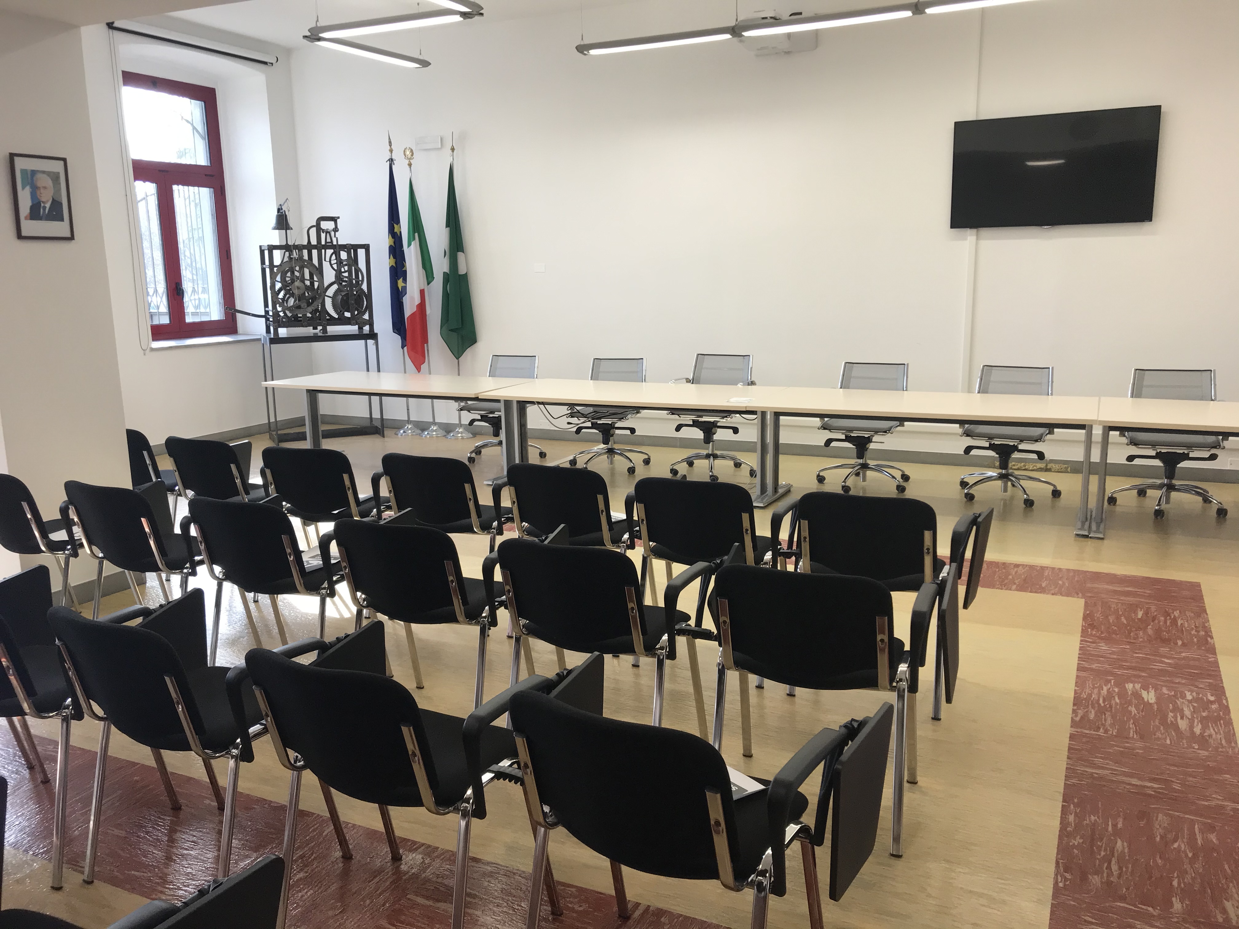 sala dell'assemblea con posti a sedere, tavolo e schermo